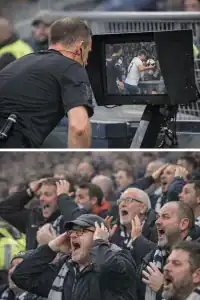 The Handball Law - an official checks a VAR monitor much to the crowds anguish